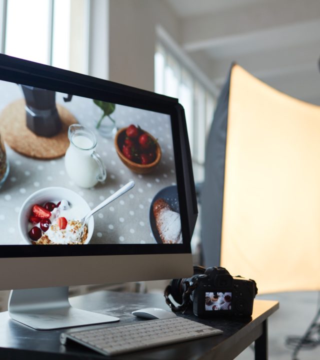 Workplace of photographer with computer monitor and photocamera
